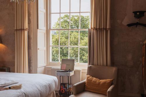 1 dormitorio con cama, ventana y silla en No 15 by GuestHouse, Bath, en Bath