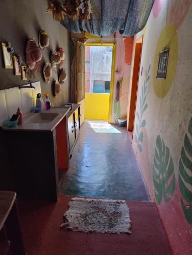 a hallway of a kitchen with a counter and a sink at Perto Do Aeroporto De Salvador - Dona Pitanga Hostel in Lauro de Freitas