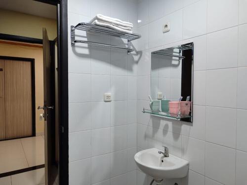 Baño blanco con lavabo y espejo en H.V HOTEL BANDARA en Gorontalo