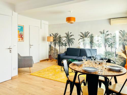 un salon avec une table et un canapé bleu dans l'établissement Le CozyCroisette - Centre Cannes - 6 personnes, à Cannes