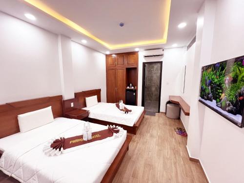 a hotel room with two beds and a flat screen tv at Paradise Cu Chi Hotel in Củ Chi