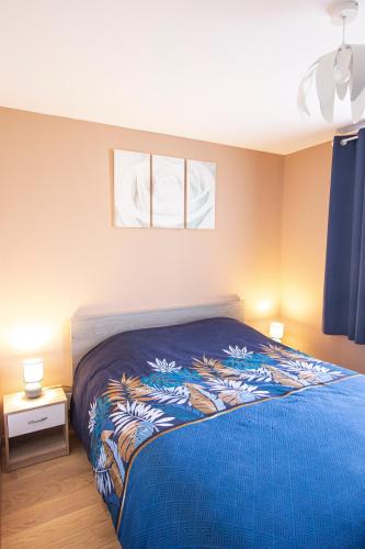 une chambre avec un lit avec une couverture bleue dans l'établissement La Maison du Lac - Puimoisson, à Puimoisson