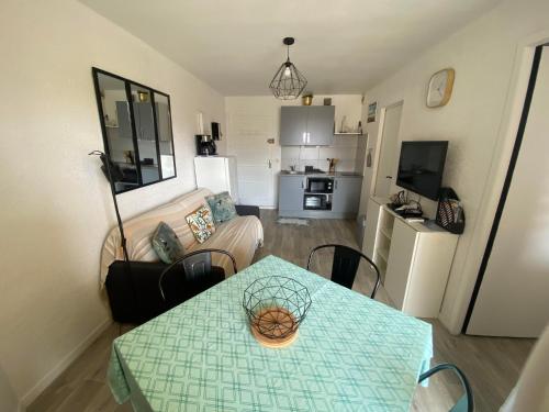 un salon avec une table et un canapé dans l'établissement Appart deux pas de la mer 4 personnes 4FRONT9, au Barcarès