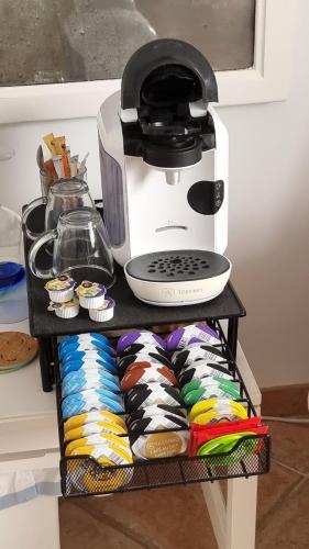 a coffee maker sitting on a shelf with cupcakes at Boutique B&B Número Cuatro in Benissa