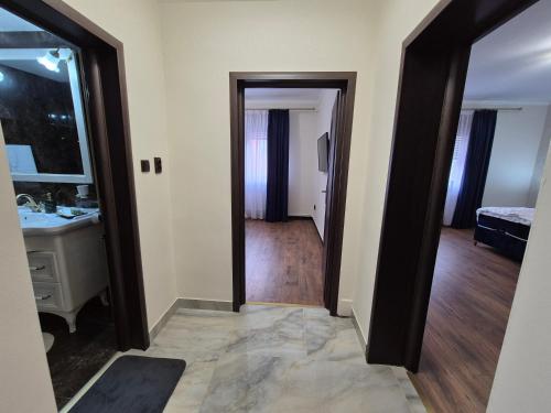 a hallway with a bathroom and a sink and a mirror at Casa Denis la 50m de Castel! in Hunedoara