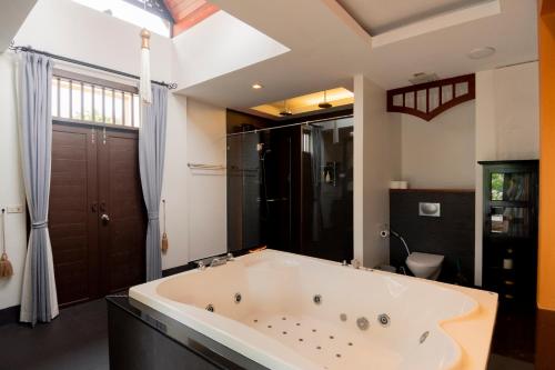 a large bathroom with a large tub in a room at Luxury Thai Style Swimming Pool Villa, Private housekeeper,6 Bedrooms in Nong Prue