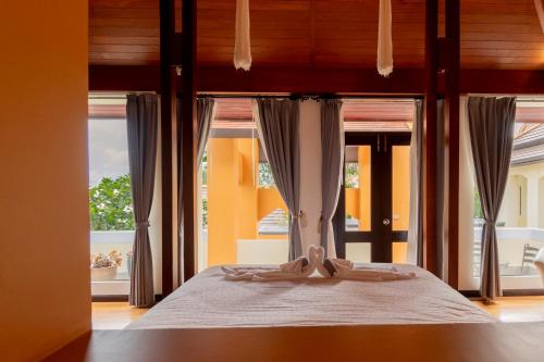 农布Luxury Thai Style Swimming Pool Villa, Private housekeeper,6 Bedrooms的一间卧室配有一张床,床上有浴袍