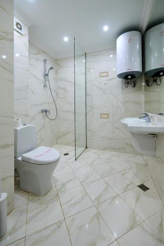 a bathroom with a toilet and a shower and a sink at Luxury Sea View Apartment in Pomorie in Pomorie