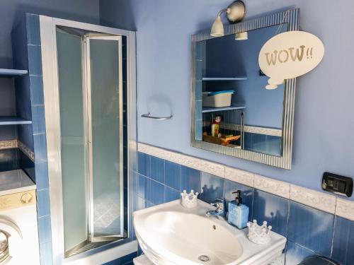 a blue bathroom with a sink and a mirror at Umberto 25 in Santo Stefano di Camastra