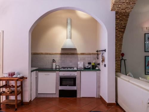 a kitchen with an archway with a stove top oven at Umberto 25 in Santo Stefano di Camastra