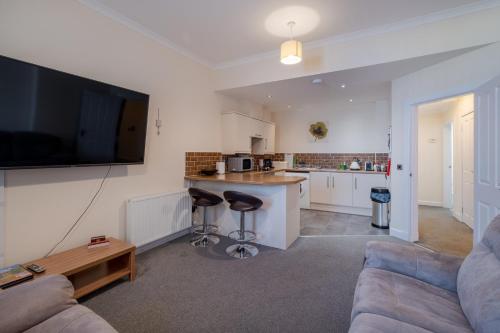 a living room with a couch and a kitchen at Spacious 2-Bedroom Condo With Free Parking On Site in Montrose