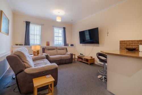 a living room with a couch and a tv at Spacious 2-Bedroom Condo With Free Parking On Site in Montrose