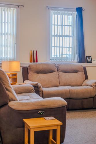 a living room with a brown couch and a table at Spacious 2-Bedroom Condo With Free Parking On Site in Montrose