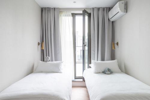 two beds in a room with a window at YAYS Antwerp Opera by Numa in Antwerp