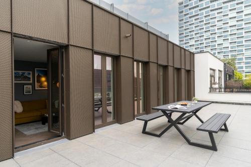a patio with a table and benches on a building at YAYS Antwerp Opera by Numa in Antwerp