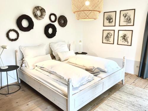 a white bed in a room with pictures on the wall at Zauberhaftes Haus in Ortenburg in Ortenburg