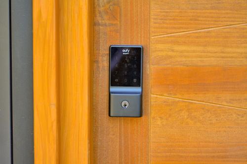 a remote control is attached to a wooden door at Enarbol Lodge, Hot Tube en terraza in Pucón