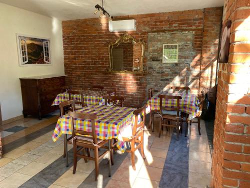 a restaurant with tables and chairs and a brick wall at La Fornace in Garessio