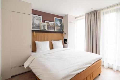 a bedroom with a large bed with white sheets at YAYS Antwerp Opera by Numa in Antwerp