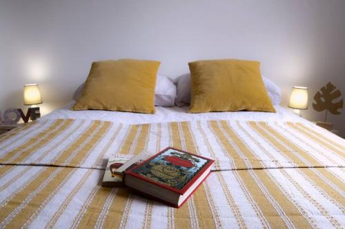 a bed with a book on it with two pillows at Villa A Funtanella 100m2, paisible, vue mer in Conca