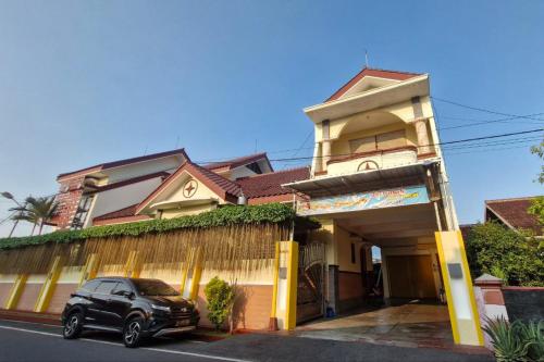 a car parked in front of a building at Reddoorz at Griya Kampar Madiun in Madiun