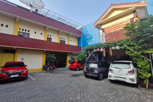 a group of cars parked outside of a building at Reddoorz at Griya Kampar Madiun in Madiun