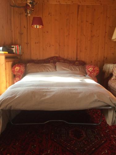 a bedroom with a bed in a wooden wall at Maso Gretel in Tesero