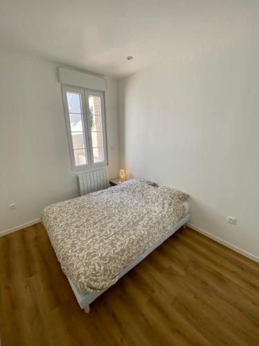 ein weißes Schlafzimmer mit einem Bett und einem Fenster in der Unterkunft L'échappée belle d'Albi in Albi