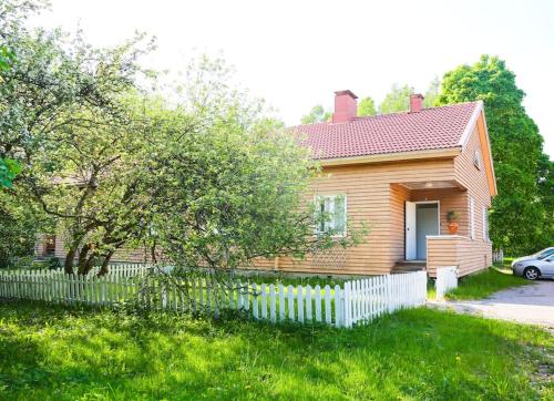 a small house with a white fence in the yard at Viihtyisä yksiö lähellä Fiskarsin ruukkia in Raasepori