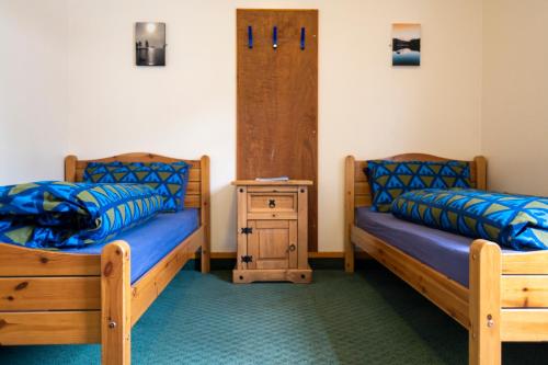 1 dormitorio con 2 camas y mesita de noche en Aviemore Youth Hostel, en Aviemore
