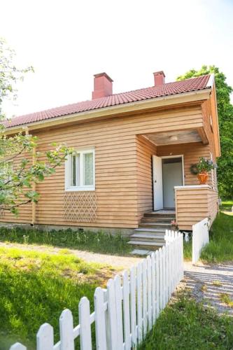 a small house with a white fence in front of it at Viihtyisä yksiö lähellä Fiskarsin ruukkia in Raasepori