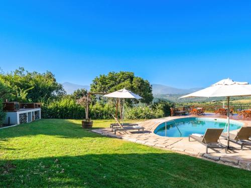 a backyard with a pool and chairs and umbrellas at Hilltop Boutique Hotel in Victoria Bay
