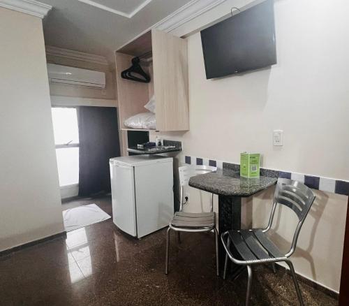 a small kitchen with a counter and a refrigerator at Hotel Buriti Stop in Goiânia