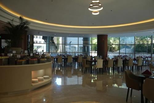 a dining room with tables and chairs in a building at Mövenpick Hotel Amman in Amman