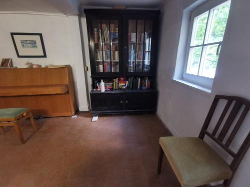a living room with a book shelf and a chair at Panoramablick in Langenburg