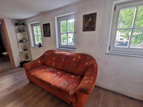 a leather couch in a living room with two windows at Panoramablick in Langenburg