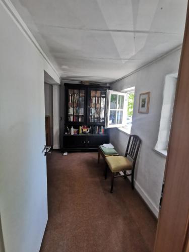 a hallway with a chair and a table and a window at Panoramablick in Langenburg