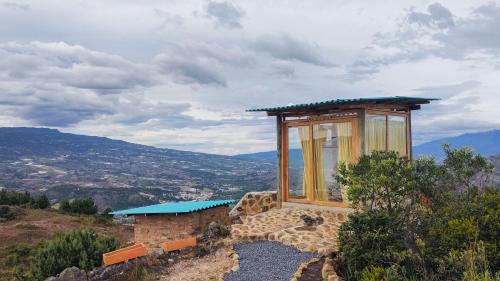 mały budynek siedzący na szczycie wzgórza w obiekcie Entre Rocas y Cristales w mieście Ráquira