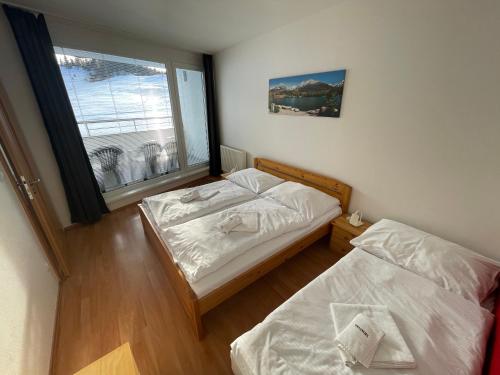 two beds in a small room with a window at Apartmán 6 Triangel in Donovaly
