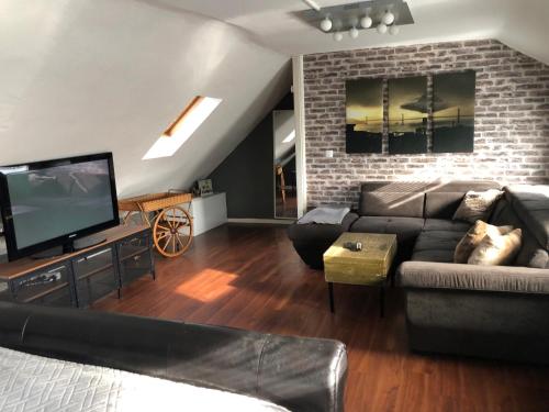 a living room with a couch and a tv at The RustyCorner- zuhause in Solingen in Solingen