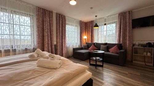 a bedroom with a large bed and a couch at Hotel Wernerwald in Cuxhaven