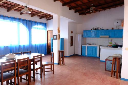 a kitchen with blue cabinets and a table and chairs at Villa de Palma a Ribeira D.Joao in Figueira da Horta