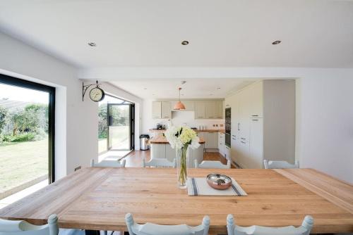 a kitchen and dining room with a wooden table at Country Chalet New Forest in Hordle