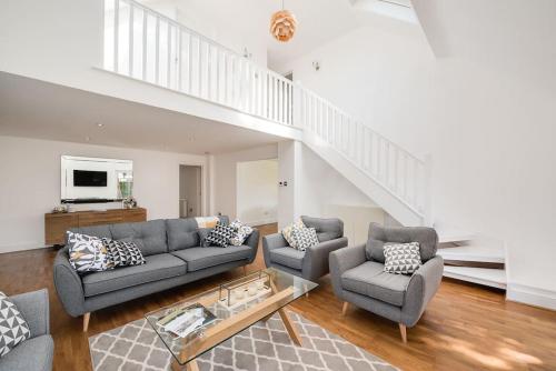 a living room with a couch and two chairs at Country Chalet New Forest in Hordle