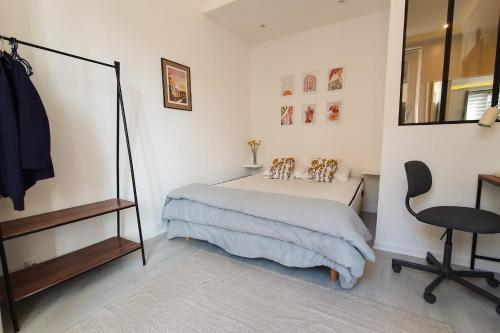 une chambre avec un lit, un miroir et une chaise dans l'établissement Cozy apartment near the sea, à Nice