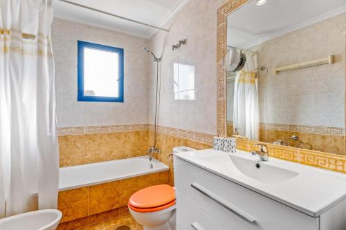 a bathroom with a toilet and a tub and a sink at Apartamento Mandarín Playamarina 2 in Orihuela