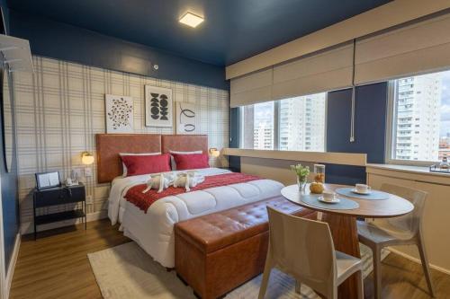 a bedroom with a large bed and a table with a table at Suíte LUXO com amenities | Hotel renomado- Paraíso in Sao Paulo