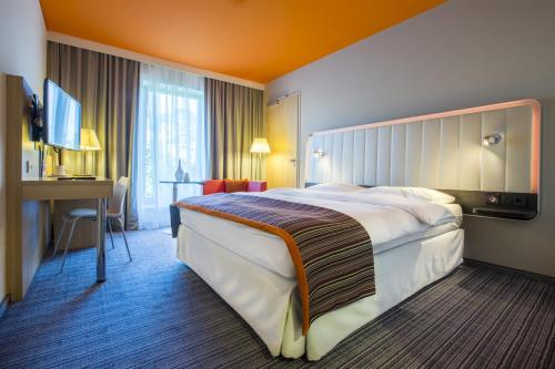 a hotel room with a large bed and a desk at Park Inn by Radisson Frankfurt Airport in Frankfurt/Main