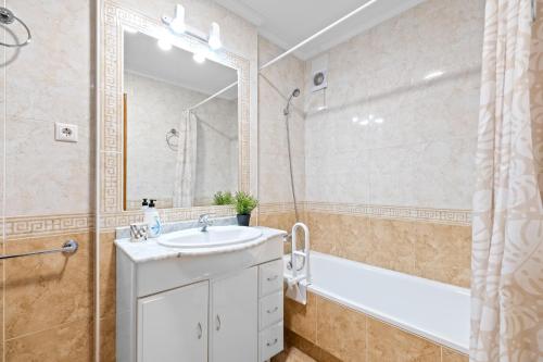 Un baño con lavabo, bañera y ducha. en Apartamento Lavanda, en Orihuela