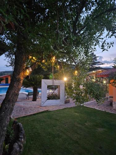 a garden with a fire pit under a tree at night at B&B Ferro di Cavallo in Tivoli
